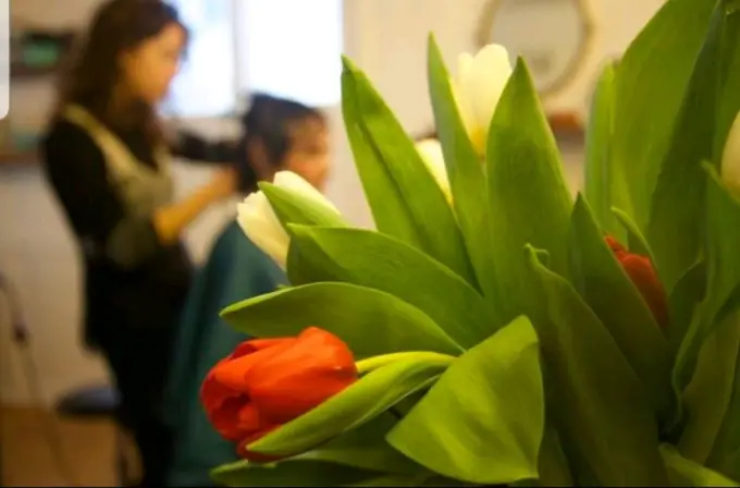 Blumen im Salon: Tulpen, dahinter wird frisiert