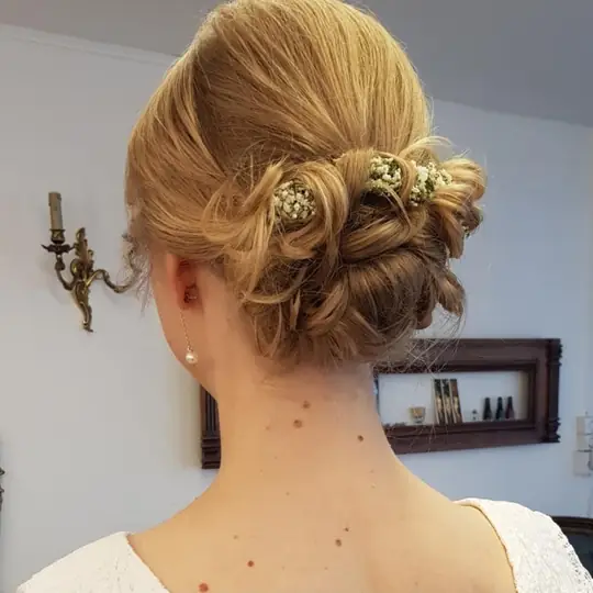 Blonde Aufsteckfrisur mit kleinen Blüten