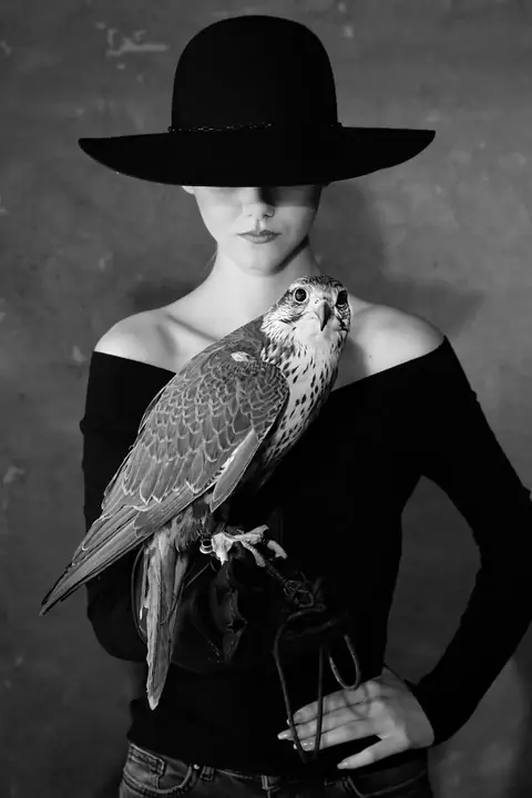 Frau mit breitem Hut und Falke