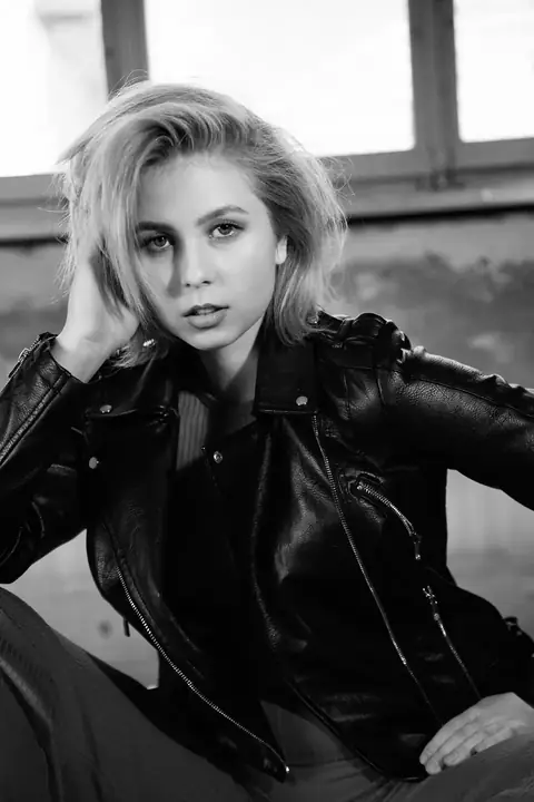 Blonde Frau in Lederjacke, die Hand im Haar